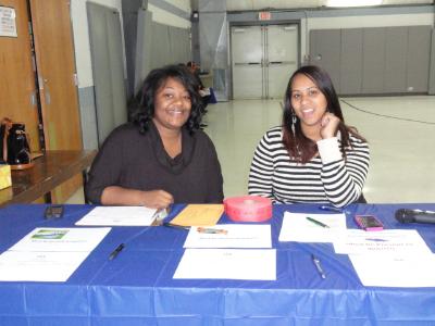 Katrina Lewis (left), of COSA, and Christy Bobo (right), COSA Housing Director, register Energy Fair guests.