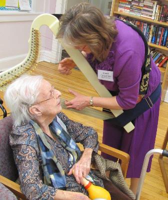 Music and Harp Therapist, Carol Carpenter, plays a personal tune for Evelyn Brennan.